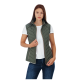 Eine Frau trägt eine grüne gesteppte Weste über einem weißen Hemd, kombiniert mit blauen Jeans, posiert mit den Händen in die Hüften gestützt.