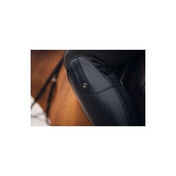 Nahaufnahme einer schwarzen Leder-Sattelklappe auf einem Pferd, die detaillierte Nähte und einen Metallknopf zeigt.