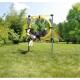 Ein schwarz-weißer Hund springt fröhlich durch einen gelben Agility-Reifen, der auf einem Rasen steht, umgeben von Bäumen und Grün.