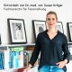 Eine Frau in einem schwarzen Shirt steht neben einem Bücherregal mit Haustierpflegebüchern, mit gerahmten Katzen- und Hundefotos. Text: "Entwickelt von Dr. Susan Kröger."