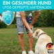 Ein Mann in einem hellblauen Hemd und Jeansshorts füttert einen Labrador Retriever in einem grasbewachsenen Feld. Text lautet "Ein gesunder Hund" und "LFGB geprüfte Materialien."