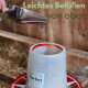 Futter wird mit einer Schaufel in einen weißen GarPet-Tierfutterspender mit rotem Rand geschaufelt; sichtbarer Text 'Leichtes Befüllen von oben'.