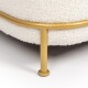 Nahaufnahme eines plüschigen, cremefarbenen Haustierbettes mit einer weichen, strukturierten Oberfläche, unterstützt von einem eleganten, goldenen Metallrahmen.