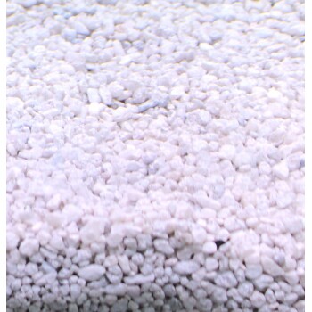 Nahaufnahme von feinen, weißen Haustierstreugranulaten, die eine weiche, sandige Textur zeigen, geeignet für Katzenstreu.