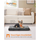 Kleiner Hund namens Frodo liegt auf einem grauen, flauschigen Haustierbett im Wohnzimmer, mit deutschem Text über den Komfort des Bettes.