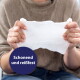 Hände dehnen ein weißes Pflegetuch, Person in braunem Pullover; blaues Siegel mit der Aufschrift "Schonend und reißfest".