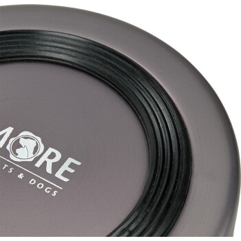 A close-up of a pet food bowl in a muted purple color, featuring the text "MORE PETS & DOGS" in white, with a black rim.