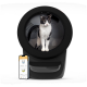 Eine schwarze automatisierte Katzentoilette mit einer Katze, die darin steht, neben einem Smartphone, das eine Schnittstelle einer Haustierpflege-App anzeigt.