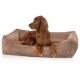 Irish Setter liegt in sandfarbenem Cord-Hundebett mit Vorderpfoten über dem Rand, Lederetikett mit der Aufschrift 'KNUFFELWUFF'.