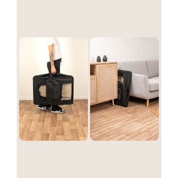 Eine Person hält eine tragbare schwarze Haustiertrage mit einem Netzfenster, neben einem Holzschrank und einem grauen Sofa in einem gemütlichen Wohnzimmer.