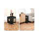 Eine Person hält eine tragbare schwarze Haustiertrage mit einem Netzfenster, neben einem Holzschrank und einem grauen Sofa in einem gemütlichen Wohnzimmer.