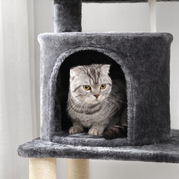 Eine graue Katze mit gelben Augen sitzt in einem gemütlichen, plüschigen Katzenbaumhaus, das eine weiche Textur und Kratzsäulen bietet.