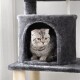 Eine graue Katze mit gelben Augen sitzt in einem gemütlichen, plüschigen Katzenbaumhaus, das eine weiche Textur und Kratzsäulen bietet.