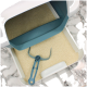 Eine saubere Katzenstreu-Box mit einer hellen Streu und einer blauen Schaufel, die darin ruht, vor einem Marmorhintergrund.