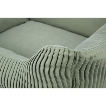 Nahaufnahme eines weichen, grünen Haustierbettes mit einem plüschigen, gerippten Äußeren und einem glatten, gepolsterten Inneren.