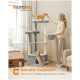 Frau spielt mit zwei orangefarbenen Katzen auf einem grauen mehrstufigen Kratzbaum mit hängenden Spielzeugen in einem Wohnzimmer.