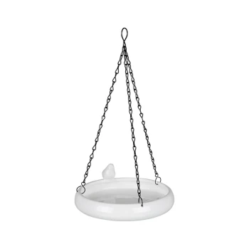 Vogeltränke Keramik Hängende weiße Keramikvogelbadewanne mit einer kleinen Vogelfigur am Rand, die von schwarzen, verdrehten Ketten gehalten wird.
