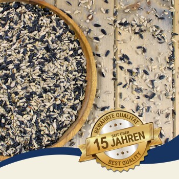 Schale mit gemischtem schwarz-weißem Vogelfutter auf einem Holztisch; goldenes Abzeichen mit der Aufschrift 'Seit über 15 Jahren', 'Bewährte Qualität', 'Best Quality'.