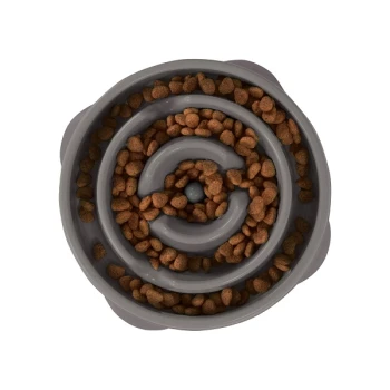 Eine graue spiralförmige Haustierfutterschüssel, gefüllt mit kleinen braunen Kroketten, von oben betrachtet.