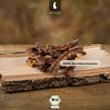 Haufen getrockneter Hähnchenhälse auf einer Holzplatte, Aufschrift '100% Bio-Hähnchenhals', Kopfzeile 'Für Hunde' und BIO-Siegel