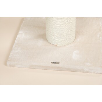 Ein weiches, beiges Haustierbett mit einer weißen Schnurspule oben, mit einem kleinen Etikett, das "AR Qualität" liest.