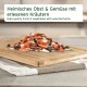 Gemischte Trockenfrüchte, Gemüseflocken und Pellets auf einem Holzbrett; Etikett auf Deutsch und Englisch: 'Früchte & Gemüse'.