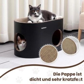 Zwei Katzen auf einem schwarzen Petrhein modernen Katzenhaus im hellen Wohnzimmer mit Sofa, rundem Couchtisch und Gartenblick.