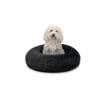 Ein flauschiger weißer Hund sitzt bequem in einem runden, dunkelgrauen Hundebett, das seine weiche Textur und sein gemütliches Design zeigt.