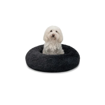 Ein flauschiger weißer Hund sitzt bequem in einem runden, dunkelgrauen Hundebett, das seine weiche Textur und sein gemütliches Design zeigt.