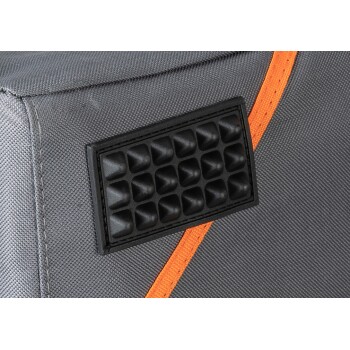 Nahaufnahme eines grauen Haustierträgers mit einem strukturierten schwarzen Gummipatch und einem orangefarbenen Akzentstreifen.