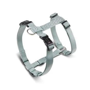 Salbeigrünes Nylon-Hundegeschirr mit verstellbaren Riemen, schwarzen Kunststoffschnallen, Metall-D-Ringen und einer schwarzen Schnalle mit kleinem weißen Logo.