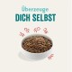 Schüssel mit Haustierfutter, gefüllt mit kleinen, runden Kroketten, umgeben von verspielten Grafiken; der Text lautet "Überzeuge DICH SELBST."