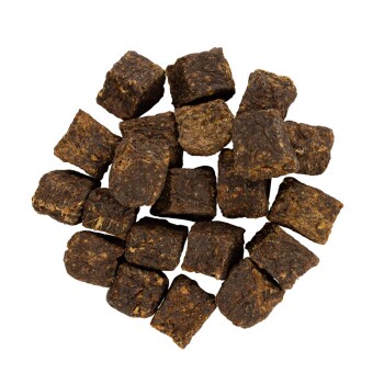 Ein Haufen dunkelbrauner, quadratischer Haustierfutterkibble-Stücke, die auf einem weißen Hintergrund angeordnet sind.