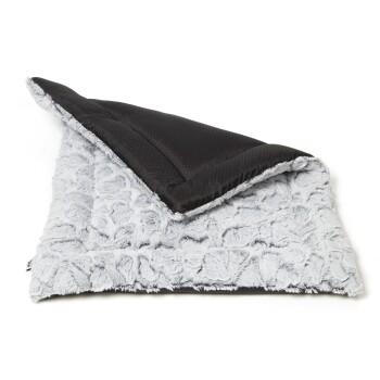 Ein weiches, plüschiges Haustierbett mit einer grauen, flauschigen Oberfläche und einer schwarzen strukturierten Unterseite, teilweise gefaltet, um beide Seiten zu zeigen.