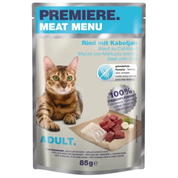 Eine Katze sitzt neben einem "Premiere Meat Menu" Beutel mit Rind und Kabeljau Haustierfutter, beschriftet mit "100% Frisches Fleisch" und getreidefrei.