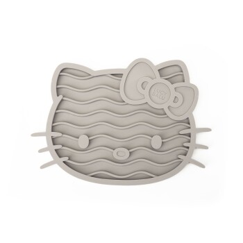 Der Rücken einer Katze ist im Vordergrund sichtbar, die auf drei bunte Silikon-Futtermatten für Haustiere in Form von Hello Kitty schaut, in Pink, Grau und Schwarz.