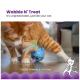 Eine verspielte orange Katze interagiert mit einem blauen Leckerli-spendenden Spielzeug, das "Wobble N' Treat" beschriftet ist und eine Federbefestigung hat.