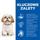 Puszysty Shih Tzu siedzi na niebieskim tle, prezentując korzyści: łatwe trawienie, witamina E, Omega-6 i zrównoważone minerały dla zdrowia.