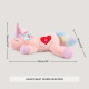 Rosa Plüsch-Einhorn mit glitzerndem Horn, Regenbogenschwanz und Herzaufnäher; Text 'HEART BEAT WARM UNICORN'.