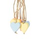 Jouets pour animaux en bois colorés en forme de cœur dans des teintes pastel de bleu, jaune et rose, suspendus à de la ficelle.