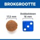 Afbeelding die de grootte van huisdiervoer-korrels vergelijkt met een blauwe dobbelsteen, met korrels van 17,5 mm en een dobbelsteen van 16 mm, gelabeld 'BROKGROOTTE' en 'Dobbelsteen.'