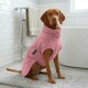Ein weicher rosa Hundemantel mit einem runden Kragen und einer Seitenöffnung für die Beine des Hundes, mit einem Etikett, das 'THE DOG IDEA' liest.