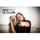 Eine Person in einer schwarzen Kochjacke zeigt mit dem Finger zur Kamera, während sie einen kleinen Hund hält. Das Logo 'MY PET CLUB' ist deutlich darüber zu sehen.