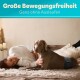 Eine Frau liegt auf einem Bett neben einem Hund, der eine blaue Hundewindel trägt. Der Text darüber lautet "Große Bewegungsfreiheit Ganz ohne Auslaufen."