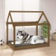 Ein gemütliches Holz-Hundebett in Form eines Hauses, mit einem grau-weißen Husky, der auf einem dunklen Kissen liegt, mit einem Fußball und einem Tennisball in der Nähe.