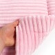 Eine Hand hält eine weiche, rosa Haustierdecke mit gerippter Textur, die ihr plüschiges Material zeigt.