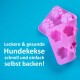 Rosa Silikonform zum Backen von Hundeleckerlis, mit Pfotenabdruckformen, mit dem Text: 'Leckere & gesunde Hundekekse schnell und einfach selbst backen!'