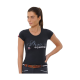 Eine Frau trägt ein enges schwarzes T-Shirt mit 'Shoes Equestrian' in glitzernden Buchstaben, kombiniert mit einem braunen Gürtel und dunklen Hosen.