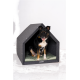 Ein schwarzer und brauner Hund sitzt bequem in einem modernen, grauen Hundehäuschen mit einem grünen Kissen und zeigt ein gemütliches Design.