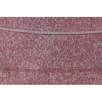 Nahaufnahme eines strukturierten rosa Stoffes mit einem weißen gesprenkelten Muster und sichtbaren Nähdetails.